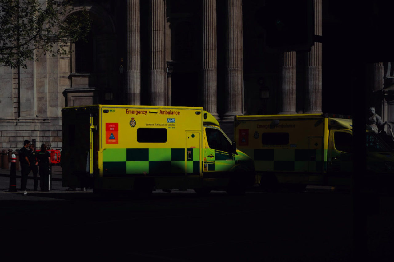 Deux ambulances jaunes garées à moitié dans l'ombre au coucher du soleil