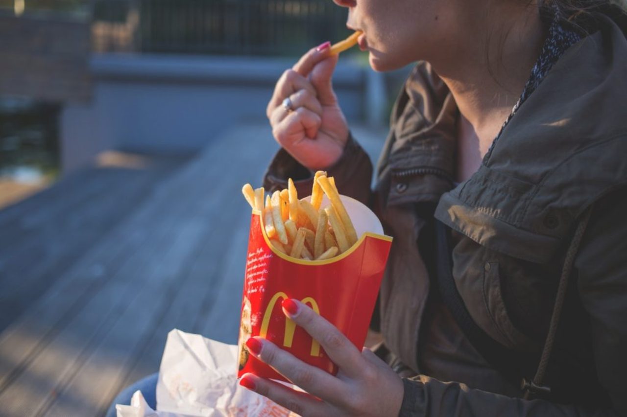 femme-en-brun-classique-trench-coat-eating-mcdo-frites-pendant-139681